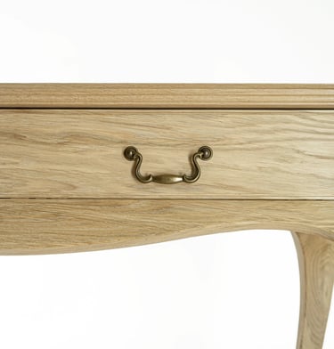 Close-up of an oak console table drawer with an antique-style metal handle