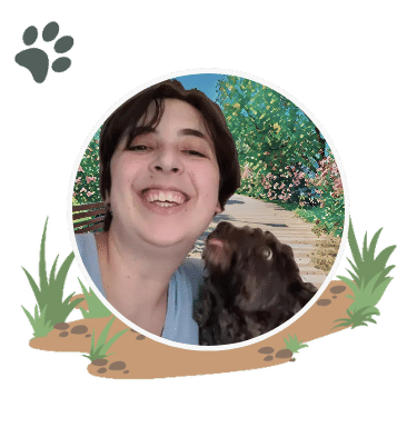 Julia Goldhirsh headshot in Boston Massachusetts with a black fluffy dog licking their face
