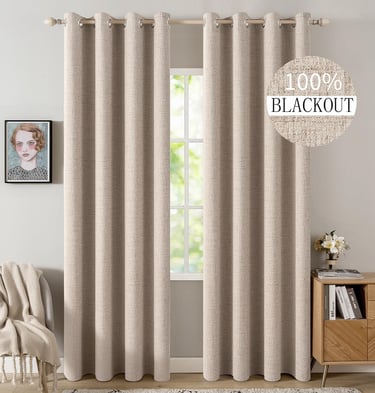 Beige textured blackout curtains hanging on a wooden rod in a modern bedroom interior.
