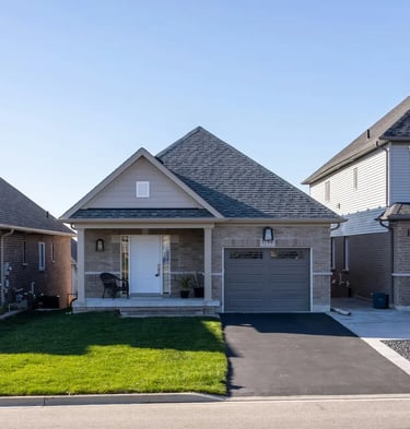 Front view of modern suburban houses with clean driveways and well-maintained lawns.