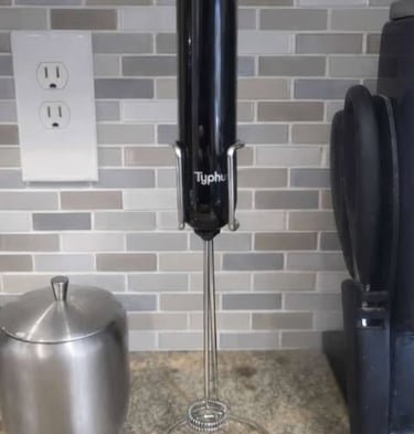 Handheld electric instawhisk milk frother on a kitchen counter