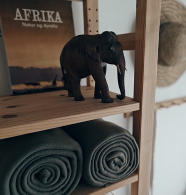 a toy elephant standing on a shelf with towels and towels