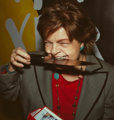 Mujer mayor divertida mordiendo un cuchillo y riendo para la marca de cuchillos Zwilling