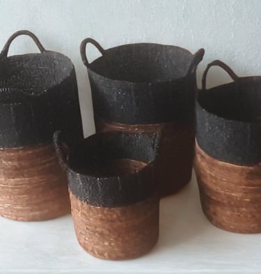 Set of four handmade seagrass storage baskets with handles in a two-tone black and natural brown design.