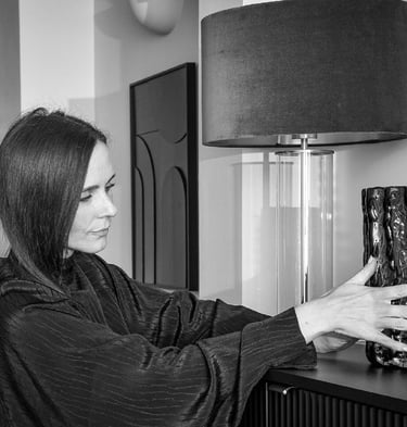 Amy Parker Williams decorating a shelf. Placing an ornament next to a lamp