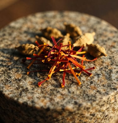 Macro shot of saffron threads and cardamom pods resting on a textured granite grinding stone, warm golden hour light, shallow depth of field, 35mm film.