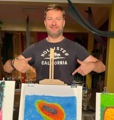 a man standing in front of a display of art work