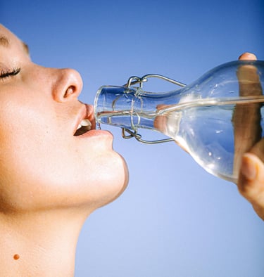 a woman drinking from a bottle of water