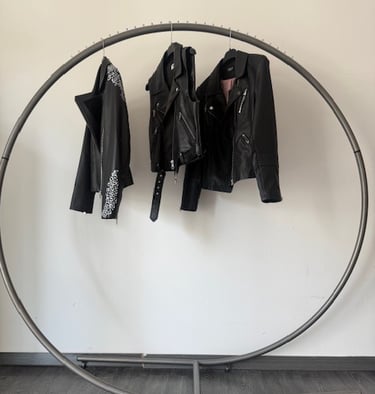 Espositore con appesi 3 giubotti in pelle neri vista frontale