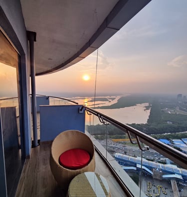 a balcony with a view of the sun setting at Zenith Suites - Noida, Supernova, Supertech