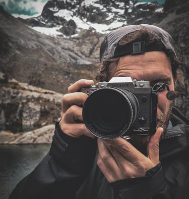Fotografia di Marco Maggini mentre tiene in mano la macchina fotografica in montagna