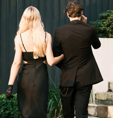 a man and woman walking down stairs in a black dress
