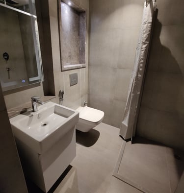 a bathroom with a shower and a toilet at Zenith Suites - Noida, Supernova, Supertech