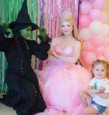 Elphaba and Glind pose with a child