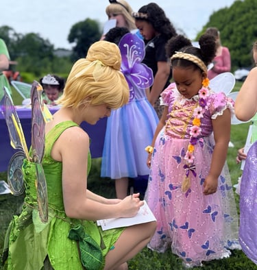 Tinker Bell signs and autograph for a child