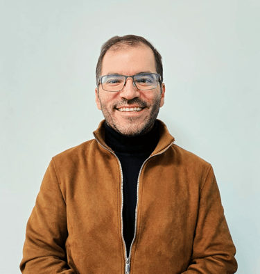 a man in a brown jacket and glasses