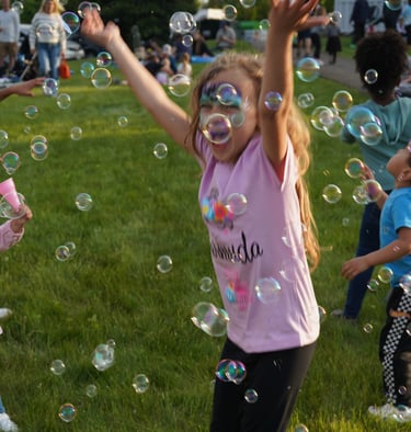 Young girl plays in bubbles