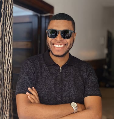 a man in sunglasses smiling and folding his arms
