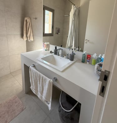 a bathroom with a sink and a bucket with soap