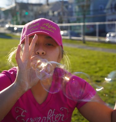 Bubble attendant blows bubbles through their fingers