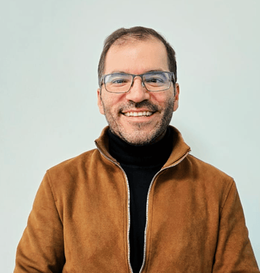a man in a brown jacket and glasses