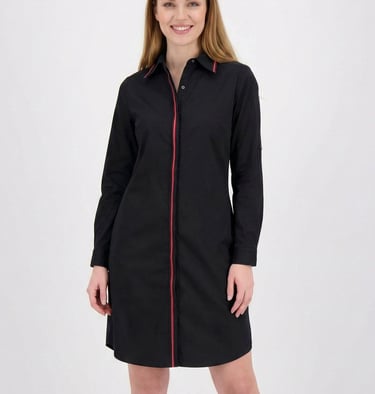 Woman wearing a black long-sleeve shirt dress with a red vertical stripe detail and button-up collar.
