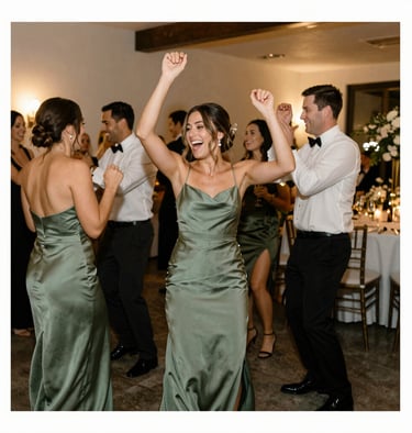 Guests dancing and laughing at a high-end North American / US wedding reception, artistic motion blur, warm interior lighting, Sage Green decor visible.