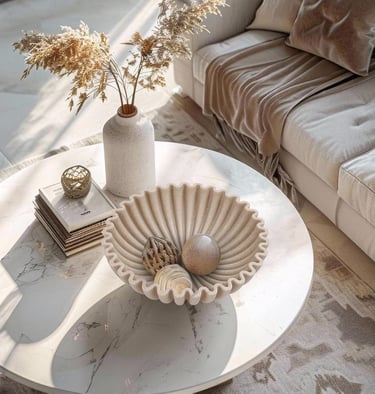 Modern living room with a marble coffee table featuring a fluted bowl and dried pampas grass decor.