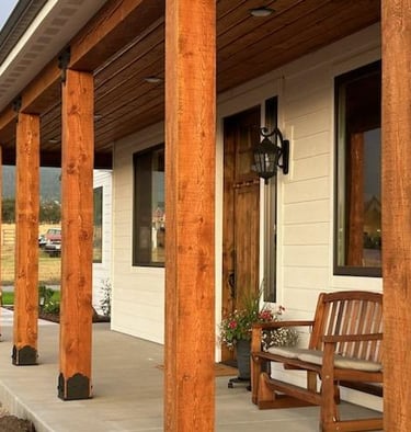 Wood beams and cement patio of custom home in Montana with mountains