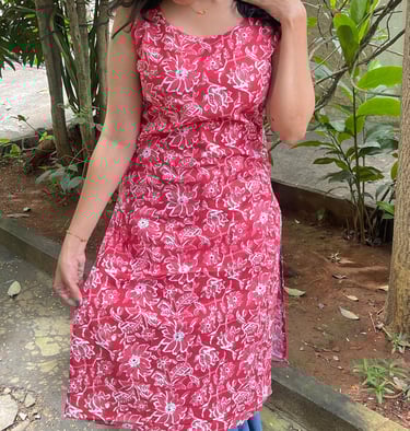 a woman in a red dress with a cat on her head
