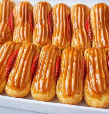 “Una bandeja de éclairs recién horneados cubiertos con un brillante glaseado de caramelo dulce 
