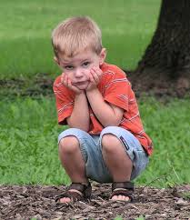 a small boy squatting