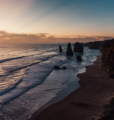 a view of the ocean and cliffs at sunset