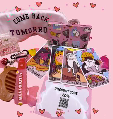 A pink collection of cat tarot cards, silk eye mask, and Hello Kitty accessories on a pink background.