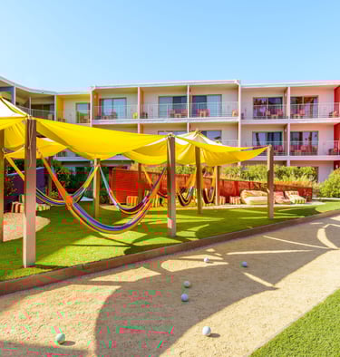 The Saguaro Palm Springs hotel with colorful rooms, shaded hammocks, and outdoor courtyard