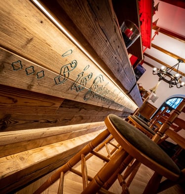 farbiger gefräster Schriftzug an einer Holzbar