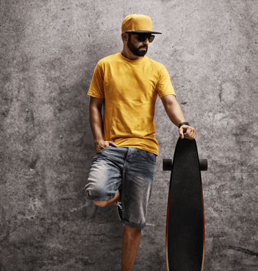 a man in a yellow shirt and sunglasses holding a skateboard