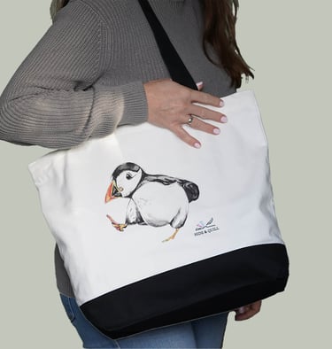 a woman holding a white bag with a puffin bird on it