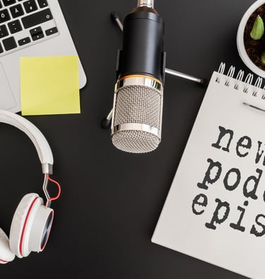 a microphone and a laptop with a notepad and a notebook