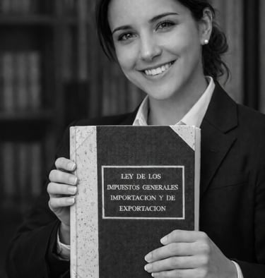 Smiling female lawyer holding a book on general import and export tax laws in a library.