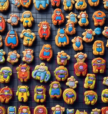 A tray of biscuits shaped like capes and shields, freshly baked and cooling.