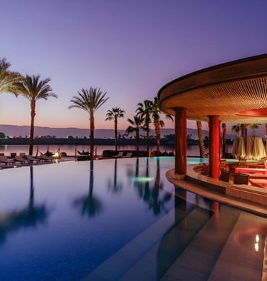 Hilton Luxor Resort & Spa infinity pool with a swim-up bar and palm trees.
