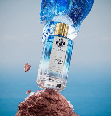 Mancera Intense French Riviera perfume bottle balanced on red rocks with a blue water splash.