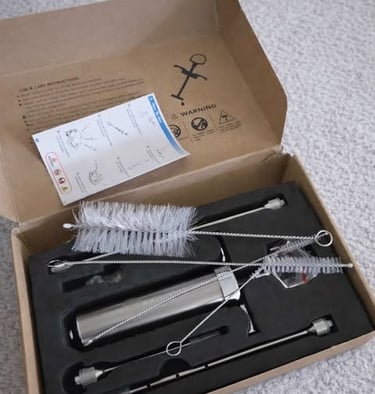 A meat thermometer in box, with attachments, and cleaning brushes in open box