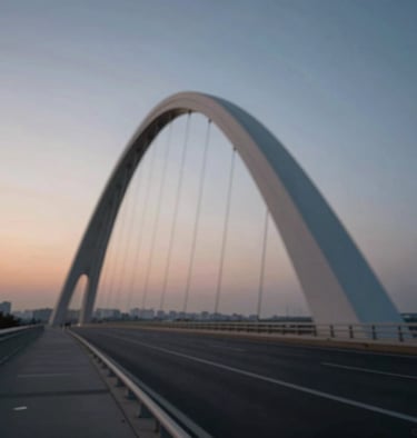 A long exposure photograph of a modern bridge structure, showing elegant curves and structural rhythm against a twilight sky.