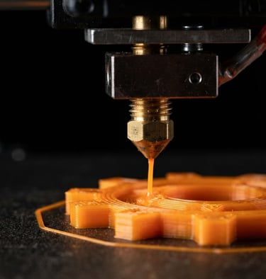 Macro shot of a high-precision 3D printer nozzle extruding vibrant orange filament, clean black background, sharp industrial studio lighting.