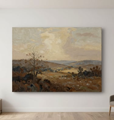 A medium shot of an original landscape painting with soft tan and muted brown hues, displayed in a bright, modern room.