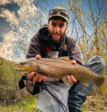 Pescador con trucha pescada en el río Órbigo en León