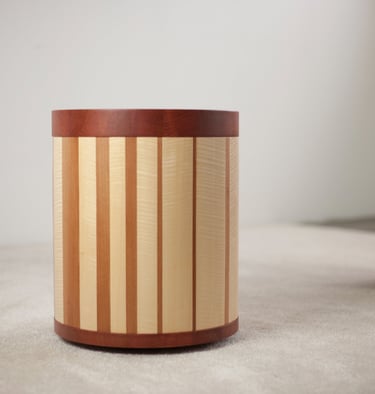 tabouret mobile plaqué de rayures irrégulières avec en arrière-plan un autre tabouret en bois sombre