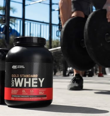 a man is holding a barbell and a bottle of whey